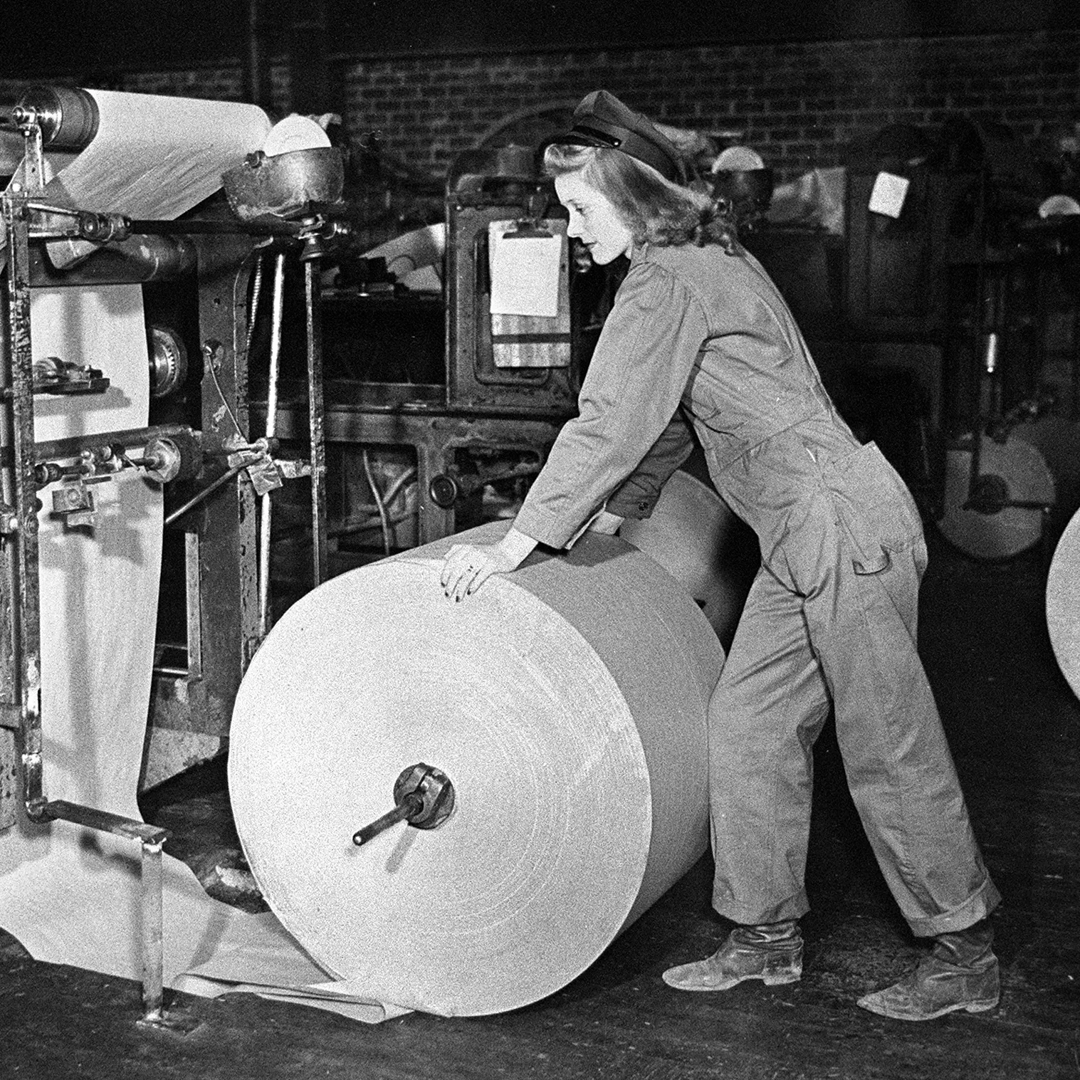 A woman rolling paper in a paper factory
